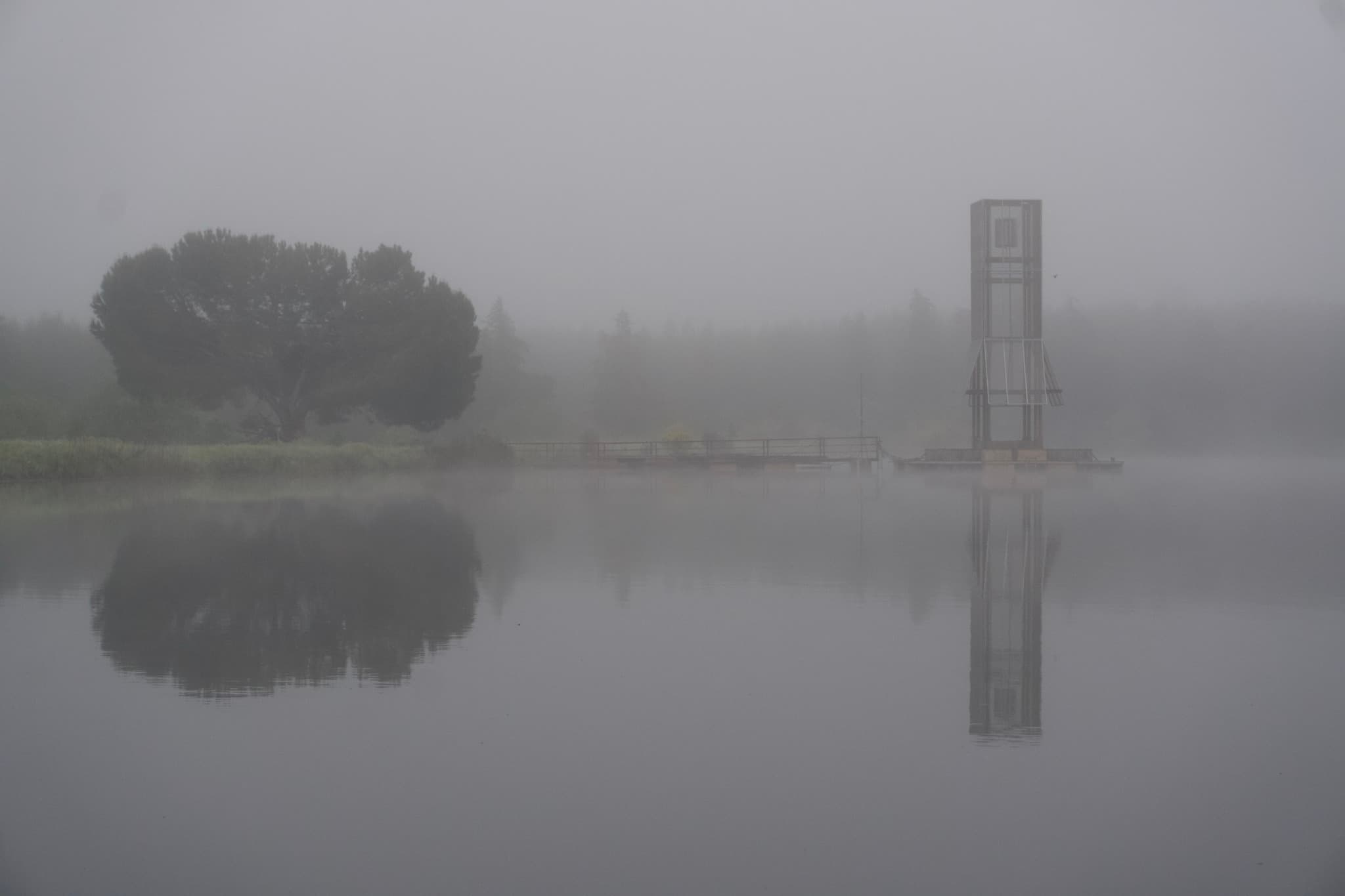 Floating lighthouse installation on a festival lake at night